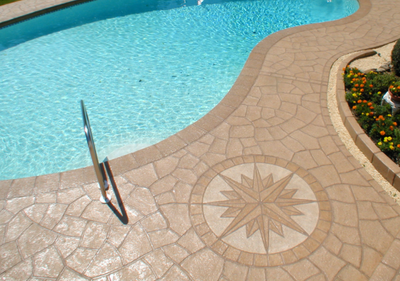 Polished and stamped concrete pool deck with a compass detail