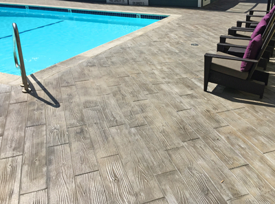 Wood grain plank style concrete stamped around a built in pool in Connecticut.